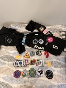 Overalls and embroidered patches arranged on a bed