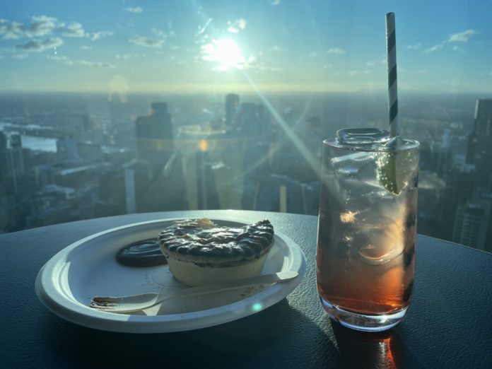 Meat Pie with Lemon Lime Bitters against a backdrop of the Melbourne CBD